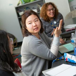 A kindergarten teacher shares her lesson ideas during a team planning session.